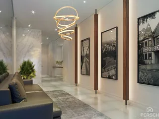 Sala de estar moderna com sofá e iluminação suspensa em um ambiente claro.