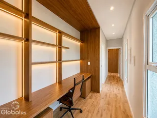 Ambiente interno com painéis de madeira e piso de madeira clara em um imóvel.