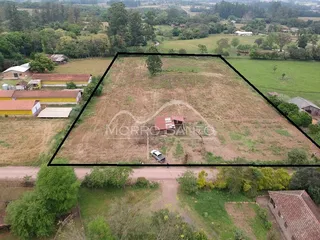 Vista aérea de um terreno aberto com vegetação e estrada de terra.