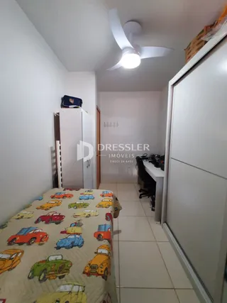 Quarto com cama e guarda-roupa em ambiente interno.