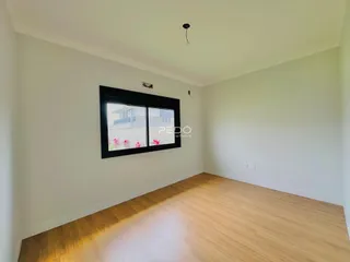 Sala de estar com piso de madeira clara e grande janela.