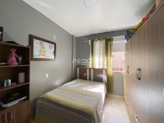 Quarto com armário e cama de madeira em um imóvel no Brasil.