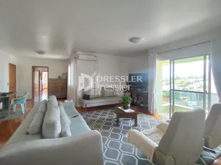 Sala de estar com sofá e poltronas claras.