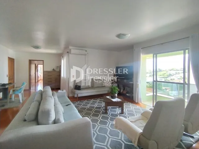 Sala de estar com sofá e poltronas claras.