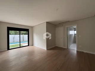 Sala de estar com piso de madeira e porta de vidro abrindo para o exterior.