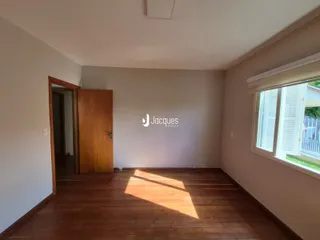 Ambiente interno com piso de madeira e janela em uma residência.
