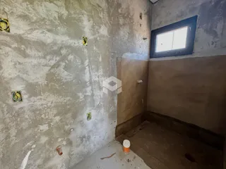 Parede interna com acabamento de concreto aparente em uma residência.