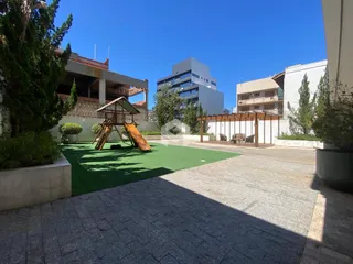 Vista externa de um quintal com gramado e área pavimentada.