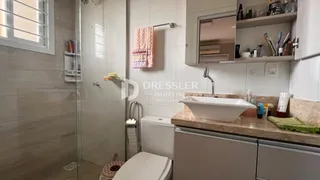 Foto de um banheiro moderno com box de vidro e louças brancas.