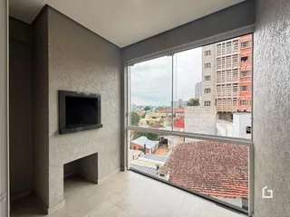 Vista interna de uma sala com grande janela para uma paisagem urbana.