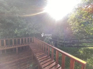 Vista de uma varanda de madeira com corrimão em uma propriedade.