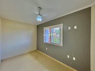 Ambiente interno de uma sala com paredes cinzas e piso claro.