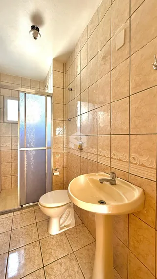 Banheiro com revestimento cerâmico nas paredes e piso.
