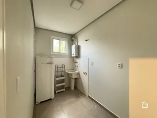 Hall de entrada com geladeira e área do banheiro.
