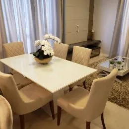 Sala de estar com móveis brancos e piso claro.