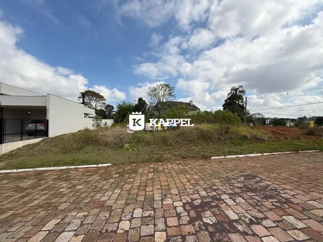 Vista externa de uma propriedade com um terreno gramado em primeiro plano.
