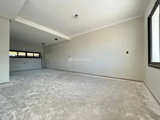 Foto de um ambiente interno vazio com piso claro e teto branco.