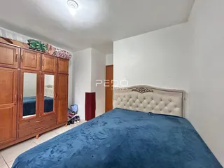 Quarto com armários de madeira e cama estofada.