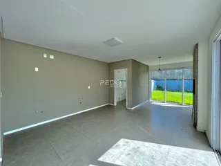 Espaço interno amplo com paredes cinzas e piso claro.