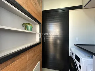 Parede com revestimento de madeira e prateleiras brancas em um ambiente residencial.