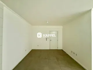 Um corredor interno com paredes brancas e piso de cerâmica.