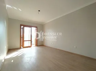 Ambiente interno de uma sala com piso de madeira clara e paredes brancas.