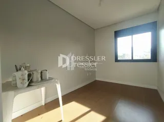Ambiente interno de uma sala com piso de madeira clara.