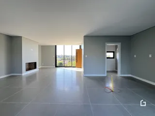 Sala de estar ampla com piso de porcelanato cinza e lareira.