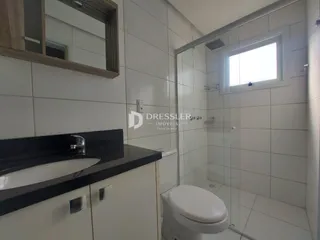 Foto de um banheiro com revestimento cerâmico branco e box de vidro.