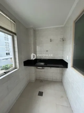 Interior de um corredor com piso de cerâmica e paredes brancas.