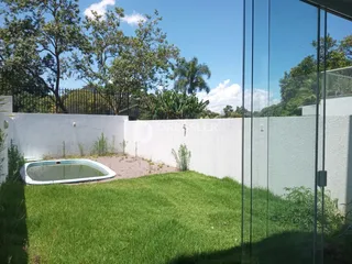 Vista externa de um jardim com piscina e muro branco em Lajeado, Brasil.