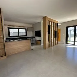 Ambiente interno com armários de madeira e piso claro em um imóvel.