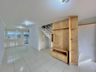 Hall de entrada com piso de cerâmica e parede de madeira em um imóvel no Brasil.