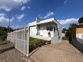Fachada de uma casa em Lajeado, Brasil, com cerca branca e paisagismo frontal.