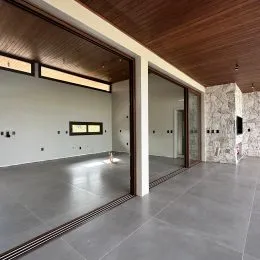 Ambiente interno com piso de concreto polido e forro de madeira exposto.