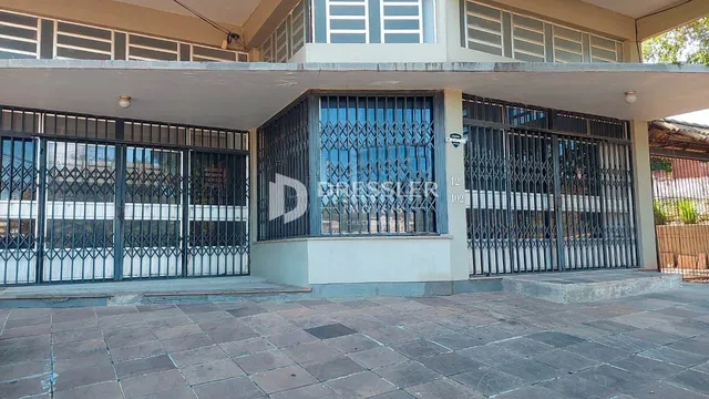 Fachada de uma residência em Lajeado, Brasil, com portões de ferro e área externa.