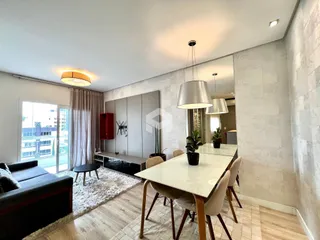 Sala de estar e jantar de um apartamento moderno com grandes janelas.