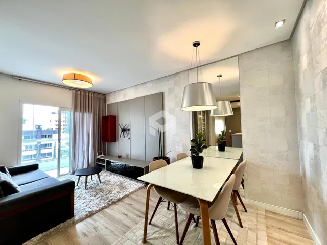 Sala de estar e jantar de um apartamento moderno com grandes janelas.