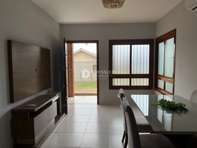Ambiente interno com piso de cerâmica e grandes janelas em uma residência.