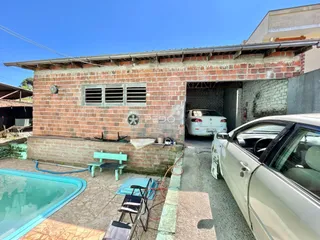 Vista externa de uma casa de tijolos com área de piscina e jardim em Lajeado.