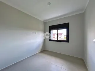 Ambiente interno de uma sala com paredes brancas e piso claro.