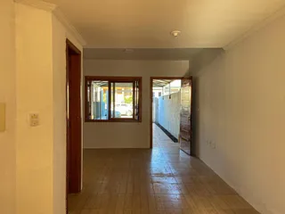 Foto de um corredor interno com piso de cerâmica e uma janela.