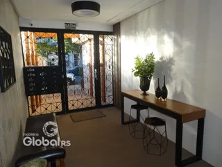 Hall de entrada com portas de ferro e piso de madeira em um imóvel no Brasil.