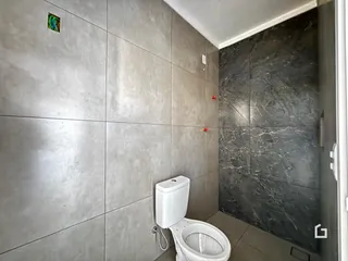 Foto do interior de um banheiro com revestimentos em tons de cinza e preto.