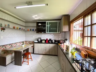 Foto de uma cozinha com área de jantar e janela em um imóvel no Brasil.