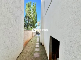 Vista de um corredor externo entre duas edificações.