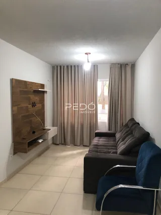 Sala de estar com cortinas e sofá em ambiente claro.