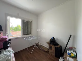 Quarto com janela e piso de madeira em imóvel no Brasil.