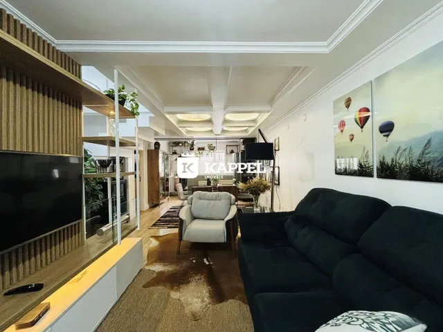 Sala de estar ampla com sofá e decoração moderna.