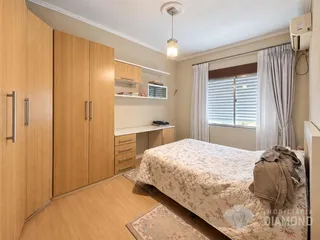 Quarto com armários de madeira e cama.